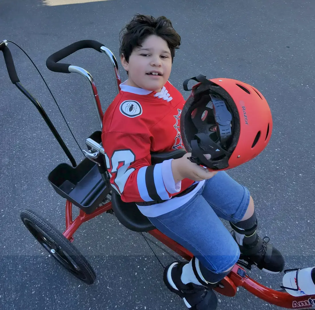Lukas with his new red Paceline 16 adaptive Tryke.